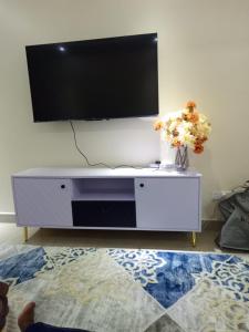 a white entertainment center with a flat screen tv on a wall at Atalia Athi River in Nairobi