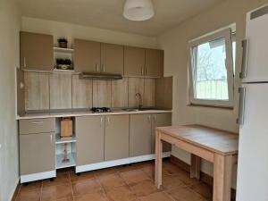 a kitchen with wooden cabinets and a wooden table at Casa Bibi in 2 Mai