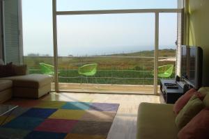 a living room with a couch and a large window at Santa Cruz Ocean View Villa in Bombardeira