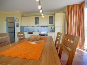 cocina y comedor con mesa de madera y sillas en Haus Möwe - Apt. 02 en Ostseebad Sellin