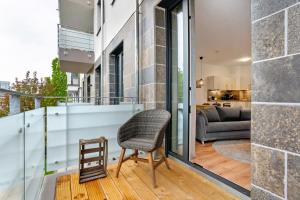 - Balcón con silla y sofá en Km Style Apartments 8, en Freiburg im Breisgau