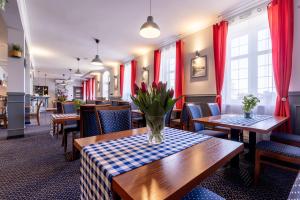 a restaurant with tables and chairs and red curtains at Hotel Diamond w Białym Dworku in Rumia