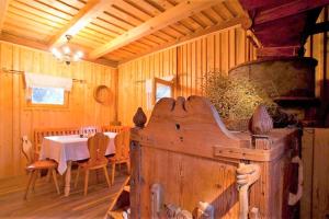 comedor con mesa y estufa de leña antigua en Green Inn Homestead With Sauna, en Dravograd