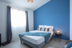 - une chambre bleue avec un lit et une fenêtre dans l'établissement villa Cocooning, à Saint-Louis
