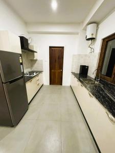 Il comprend une cuisine équipée d'un réfrigérateur et d'un comptoir. dans l'établissement Dzi Apartments, à Thimphou