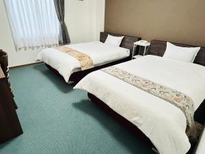 two beds in a hotel room withacers at グリーンホテル会津 in Aizuwakamatsu