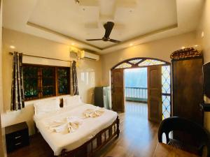 a bedroom with a bed with white sheets and a window at Seaside Divine in Calangute