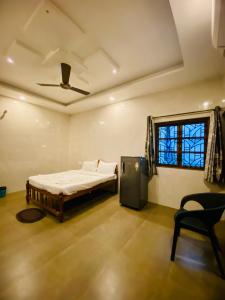 a bedroom with a bed and a chair and a window at Seaside Divine in Calangute