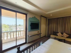 una camera d'albergo con un letto e una grande finestra di Rajwadu The Village a Jamnagar