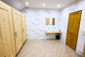 a bathroom with a sink and a stone wall at Turistické ubytovanie Sova in Ždiar