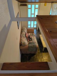 a person laying on a couch in a room with stairs at Secret Garden Petite Home Lagonissi Attiki in Kalívia Thorikoú