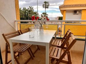 a white table and chairs with flowers on a balcony at Casa Rio in Rojales