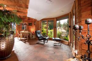 a living room with chairs and a table and windows at Chalet Podgorje With Pool in Slovenj Gradec