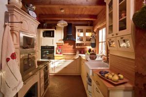 a kitchen with white cabinets and a bowl of fruit on the counter at Chalet Podgorje With Pool in Slovenj Gradec