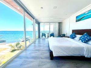 Schlafzimmer mit einem Bett und Meerblick in der Unterkunft Porto Novo Anilao Dive and Leisure Resort in Mabini
