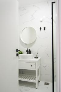 ein weißes Badezimmer mit einem Waschbecken und einem Spiegel in der Unterkunft S&B Apartment in Koper