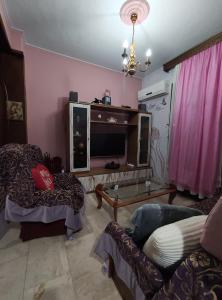 a living room with a couch and a tv at Kalys House in Kavála