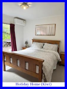 Swanson的住宿－西奧克蘭浪漫懷舊度假屋，一间卧室设有一张大床和一个窗户。