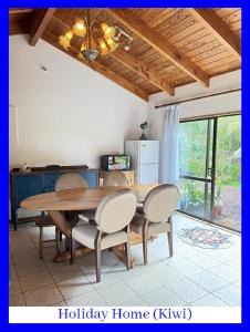 Swanson的住宿－西奧克蘭浪漫懷舊度假屋，一间带木桌和椅子的用餐室