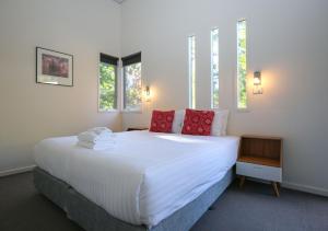 a bedroom with a large white bed with red pillows at Hygge in Harrietville