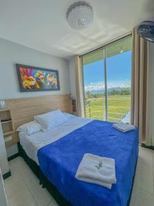 Un dormitorio con una cama azul y una ventana en APARTAMENTO TURISMO PARQUE DEL CAFE -Montenegro QUINDIO, en Montenegro