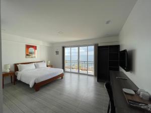 Schlafzimmer mit einem Bett und Meerblick in der Unterkunft Porto Novo Anilao Dive and Leisure Resort in Mabini