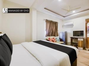 a hotel room with a bed and a tv at Super Collection O Dabolim Near Goa International Airport in Marmagao