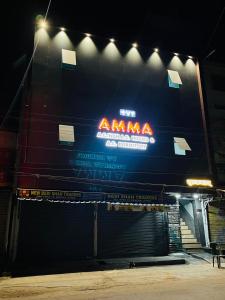 una señal en el lateral de un edificio por la noche en AMMA ROOMS AND DORMITORY, en Raipur