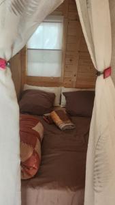 ein großes Bett in einem Zimmer mit Fenster in der Unterkunft Cabana Exotique Piscine et Jacuzzi in Porto-Vecchio