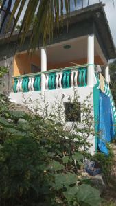 een huis met een blauwe en witte reling bij Port Antonio Brian's Beach House in Port Antonio