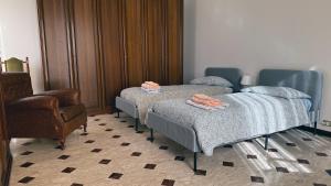 una habitación de hospital con 2 camas y una silla en Villa Teresina Noli en Noli