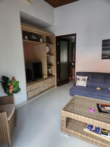 a living room with a couch and a tv at Taman Kesari Villas in Sanur