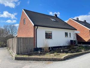 uma casa branca com uma casa de tijolos vermelhos em Holiday home SPÅNGA em Estocolmo