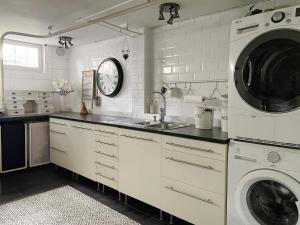 uma cozinha com um lavatório e uma máquina de lavar e secar roupa em Holiday home SPÅNGA em Estocolmo