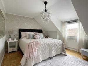 um quarto com uma cama e um lustre em Holiday home SPÅNGA em Estocolmo