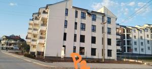 a large white building with an orange object in front of it at Apartman Reina in Soko Banja