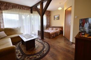 シュチルクにあるPensjonat Krokusのソファとテーブルのあるリビングルーム +7枚の写真