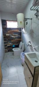 a bathroom with a toilet and a sink at Hotel Badrinath in Badrinath