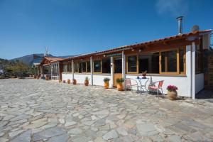 un edificio con una mesa y sillas en un patio de piedra en Skapani's House en Mésa Lasithákion