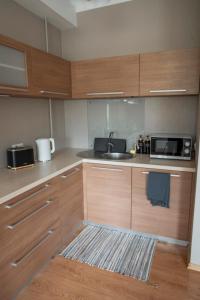 a kitchen with wooden cabinets and a sink and a microwave at Nice&cozy flat No7 in Rīga