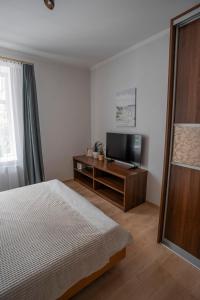 um quarto com uma cama e uma televisão de ecrã plano em Nice&cozy flat No7 em Riga