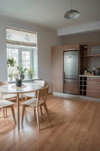 uma cozinha com uma mesa e cadeiras e um frigorífico em Nice&cozy flat No7 em Riga