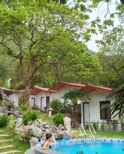 a woman sitting in a pool in front of a house at Tran Chau Garden Home in Cat Ba