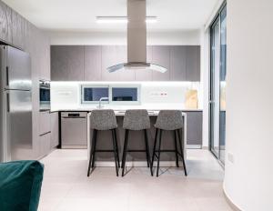 a kitchen with a island with bar stools at Venus Apartment in Larnaca