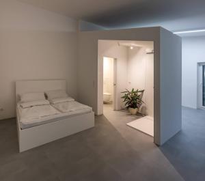 ein Schlafzimmer mit einem Bett in einem weißen Zimmer in der Unterkunft 4lofts 