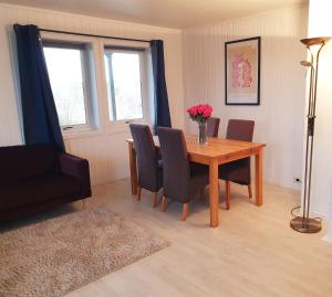 Spacious 2 Bedroom Apartment in Arendal. في أريندال: غرفة طعام مع طاولة وكراسي خشبية