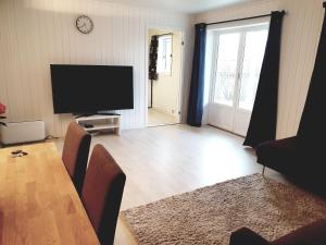 a living room with a table and a flat screen tv at Spacious 2 Bedroom Apartment in Arendal. in Arendal