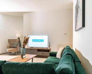 Una sala de estar con un sofá verde y un televisor. en Venus Apartment, en Lárnaca