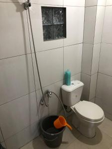 een badkamer met een toilet en een emmer bij Jasmine Homestay Syariah in Jepara