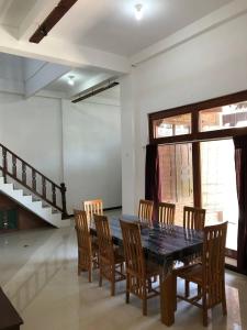 a dining room with a table and wooden chairs at Jasmine Homestay Syariah in Jepara